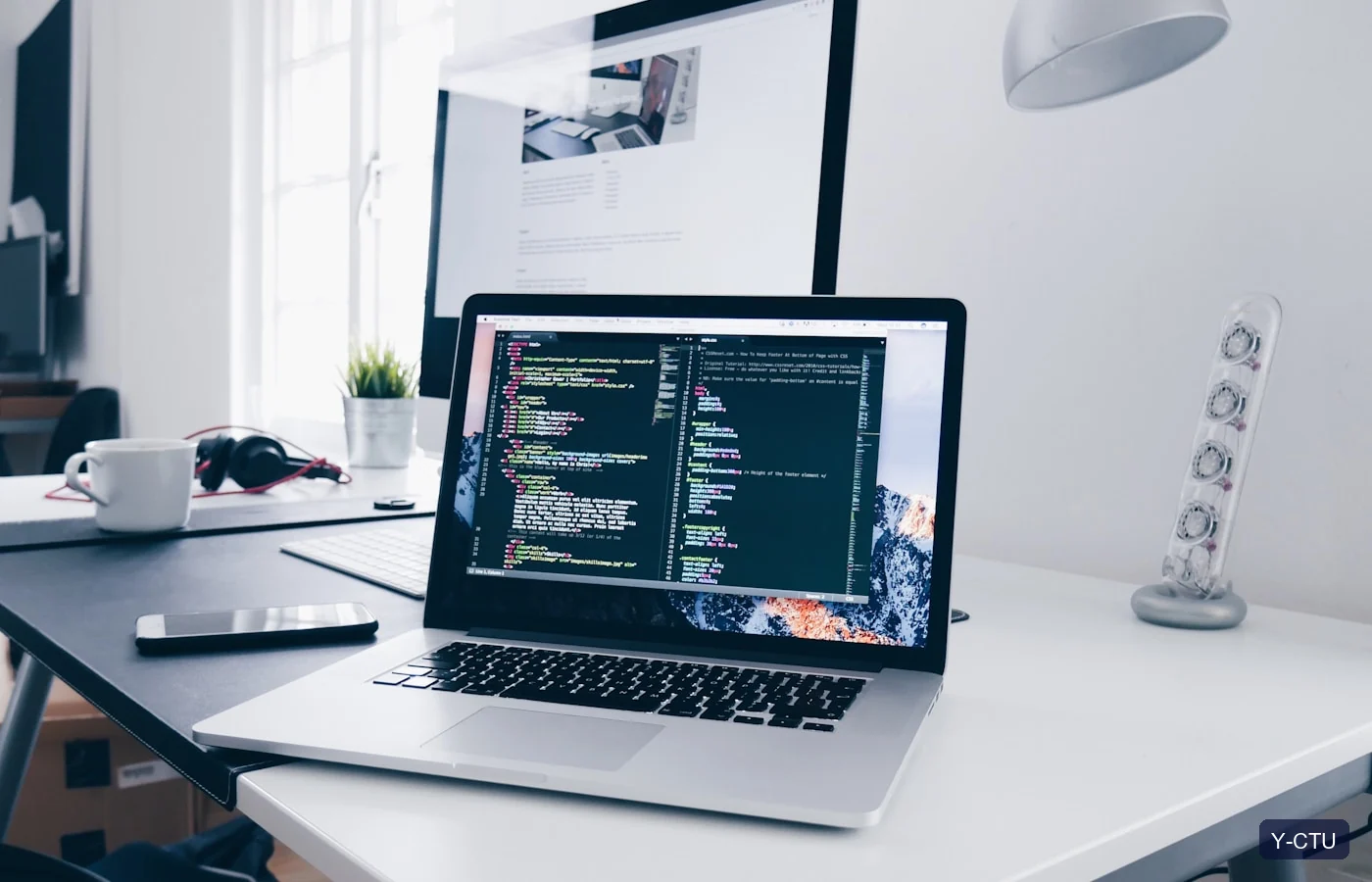 Developer writing web application code on a laptop.